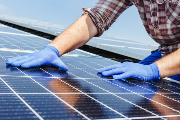 istock Male worker hands in glows on solar panel, technician installing solar panels on roof. Alternative energy sun energy power, ecological concept. 1370022787