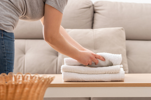 mujer doblando toallas blancas limpias photo