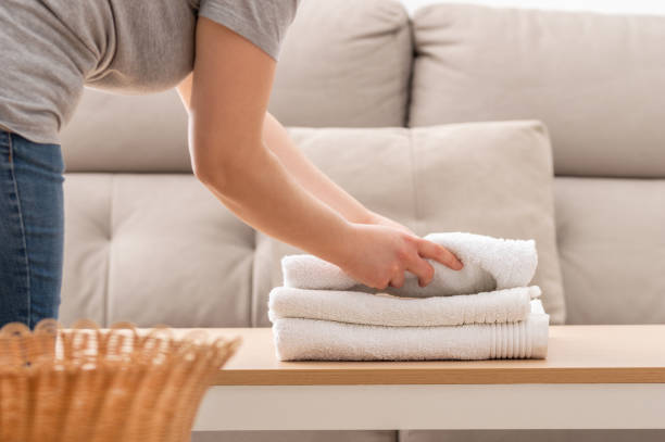 woman folding up clean white towels Cropped shot of an unrecognizable woman folding up clean white towels at home Clothing Care stock pictures, royalty-free photos & images