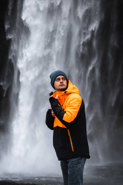 istock A young man standing in front of Seljalandsfoss in Iceland 1370025723