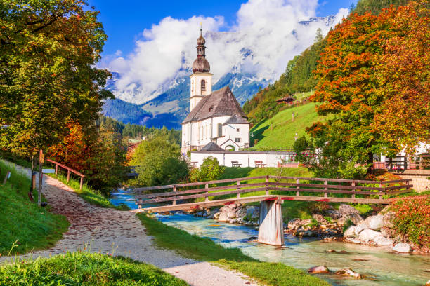 Ramsau bei Berchtesgaden, Germany. Autumnal scenery of Ramsau National Park in Berchtesgadener Land in Bavaria with incredible seasonal view of Parish Church of St. Sebastian and River Ramsauer Ache.