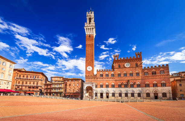 Siena, Italy - Piazza del Campo and the Mangia Tower Siena, Italy. Sunny summer scenic Piazza del Campo, Palazzo Pubblico and Mangia Tower (Torre del Mangia) in Siena. Architecture and landmarks of Tuscany. torre del mangia stock pictures, royalty-free photos & images