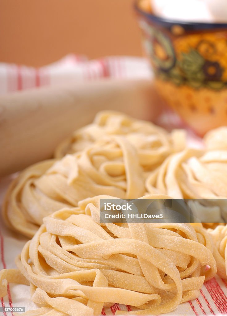Fresh handmade pasta Delicious freshly made fettuccine pasta with eggs and rolling pin Bowl Stock Photo