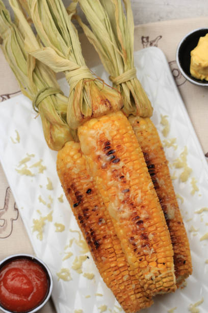 istock Grilled Sweet Corn with Butter and Shredded Mozarella. Served on White Plate 1370038079