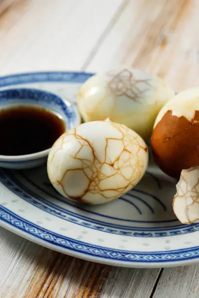 Close Up Chinese Food Boiled Marble Herbal Tea Egg on Rustic Wooden Table Top. Cha Ye Dan with Soy Sauce