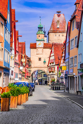 Rothenburg, Germany - June 2021. Generic touristic landmark Markusturm and beautiful street in Rothenburg ob der Tauber with traditional German houses, Bavaria