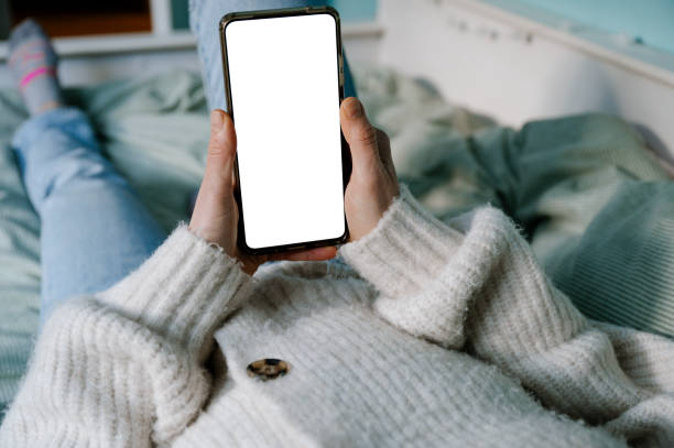 istock Woman holding a smart phone with a blank screen 1370039191