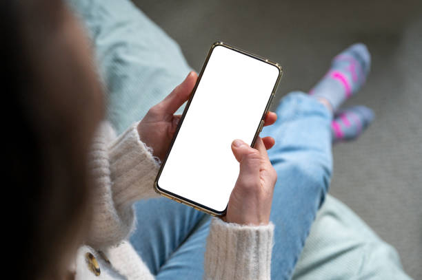 istock Woman holding a smart phone with a blank screen 1370039223