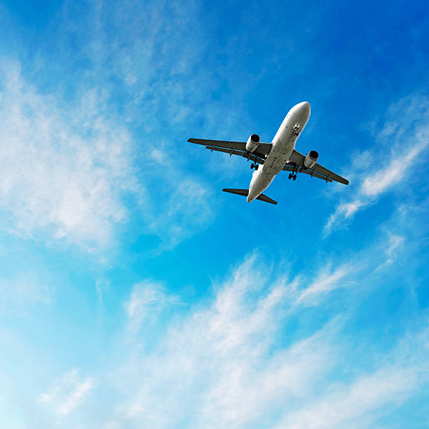XL jet airplane landing in bright sky jet airplane landing in bright wispy sky, square frame (XL) plane below stock pictures, royalty-free photos & images