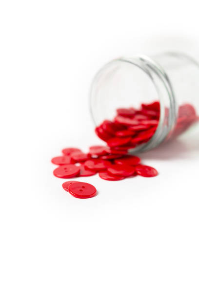 istock Jar of Red Buttons Spilling out on White Background 1370042932