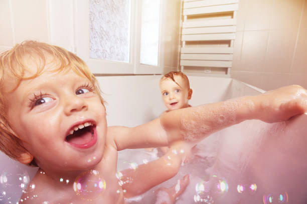 istock Two babies have fun and play in the bath together 1370046993