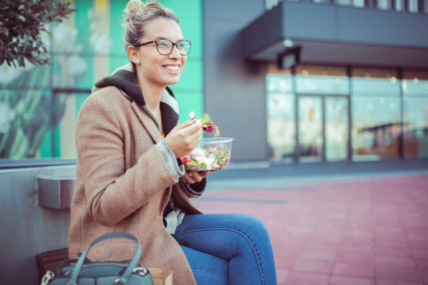 istock A woman who is casually dressed eats a healthy salad. 1370047072