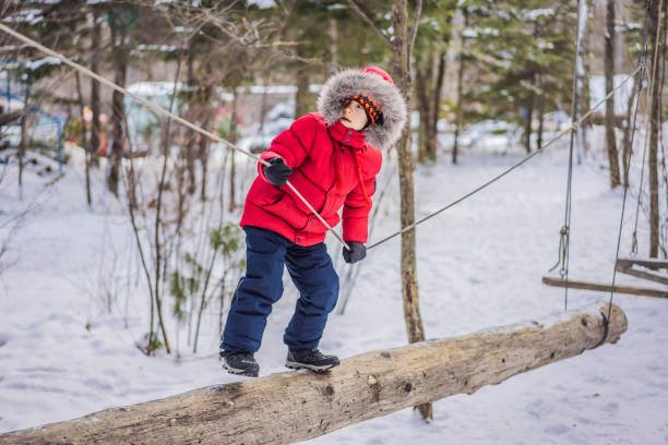 bambino felice che si gode l'attività in un parco avventura di arrampicata in una giornata invernale - 5487 foto e immagini stock