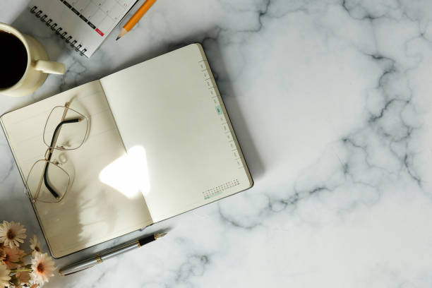 istock Top view notebook, eyeglasses, and coffee cup on marble background. 1370060277