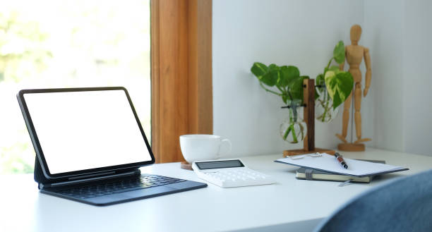 istock Digital tablet with wireless keyboard, houseplant and coffee cup on white table. 1370060393