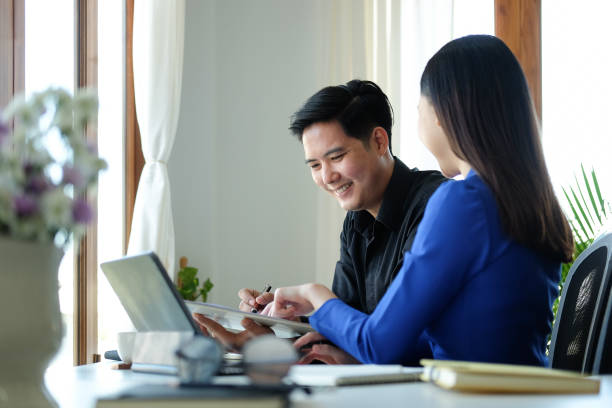 istock Two smiling business colleagues working on new project together. 1370060401