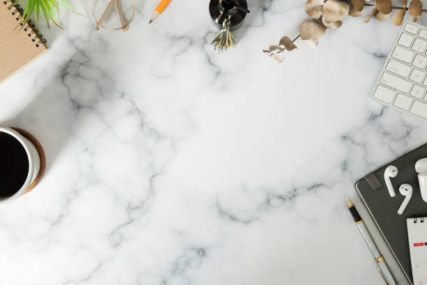 istock Woman workspace with notebook, coffee cup and wireless ear phones on marble table. Top view. 1370061285
