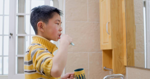 istock little boy brushing teeth in bathroom 1370062494