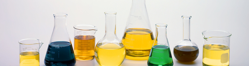 A row of flasks and beakers used in a scientific laboratory.
