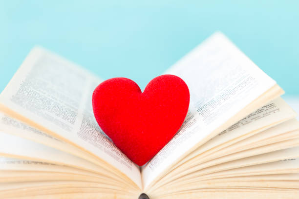 istock Red heart on old english book with space on blurred blue background 1370064197
