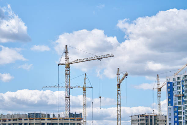 istock Construction cranes on background of cloudy sky. 1370066839
