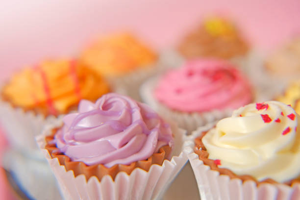 Cream cupcakes.cakes on a pink background.Cream dessert. Assorted sweet table