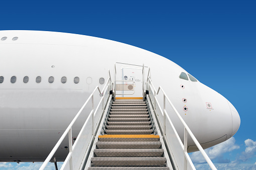 passenger boarding stairs leading to big jet plane entrance