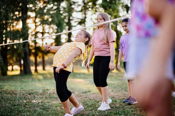 Children in the summer camp play limbo and have fun