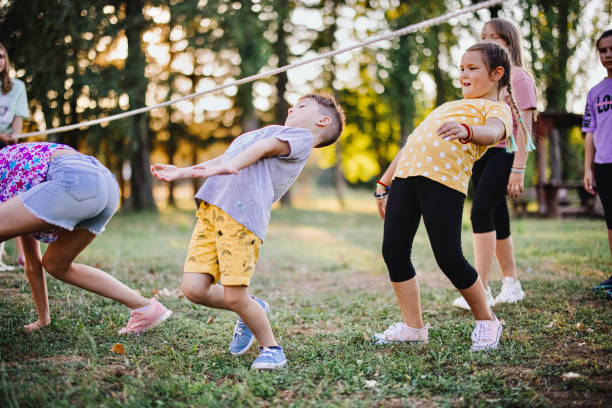 Children in the summer camp play limbo and have fun