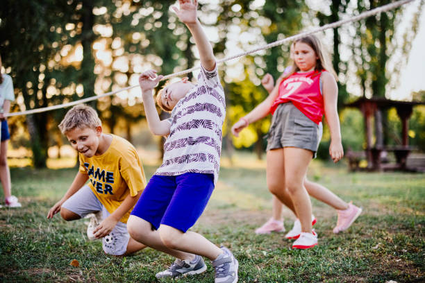 Children in the summer camp play limbo and have fun
