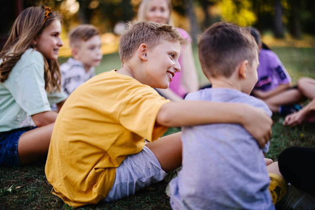 Portrait of happy children during conversation  sitting on stairs outdoors at sunny day