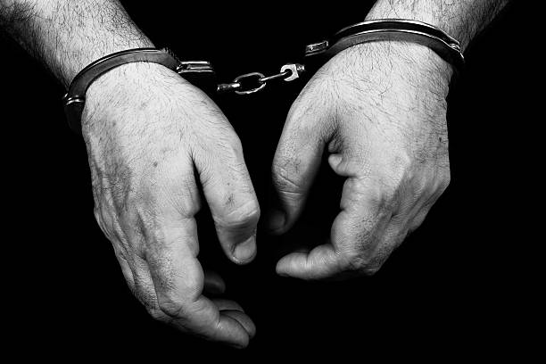 Black and white image of hands in handcuffs Black and white picture of a prisoner with cuffs officer military rank photos stock pictures, royalty-free photos & images