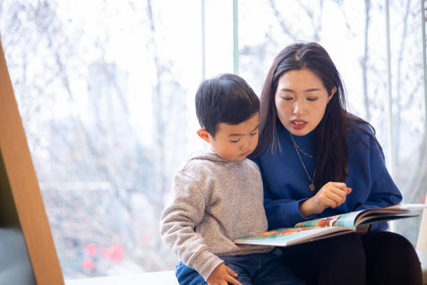 istock Mother with her son reading a book 1370088530