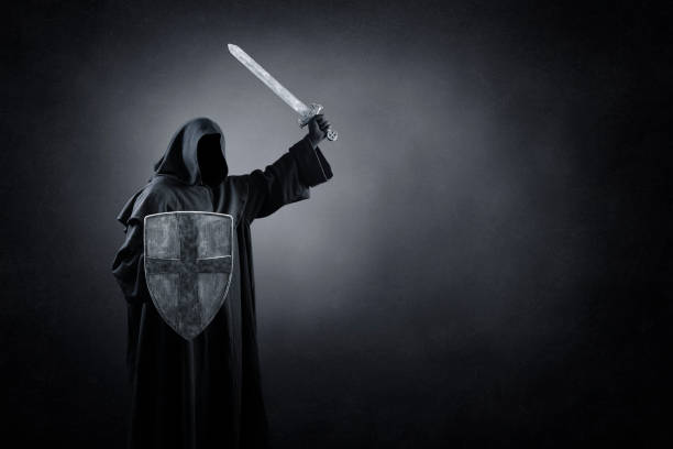 Dark knight with sword and shield in the darkness of the night Dark knight with sword and shield in the darkness of the night ceremonial robe stock pictures, royalty-free photos & images