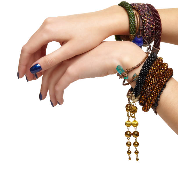 istock Female hands with handmaid bijouterie bracelets. Nails with blue manicure 1370089281