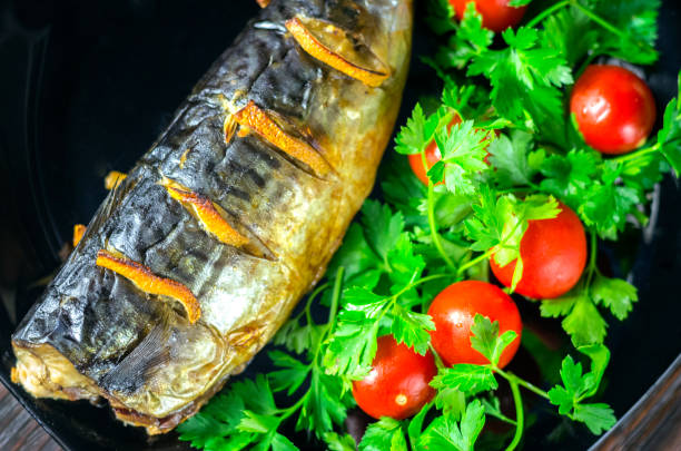 Mackerel baked with lemon. Fish on a plate with vegetables close-up