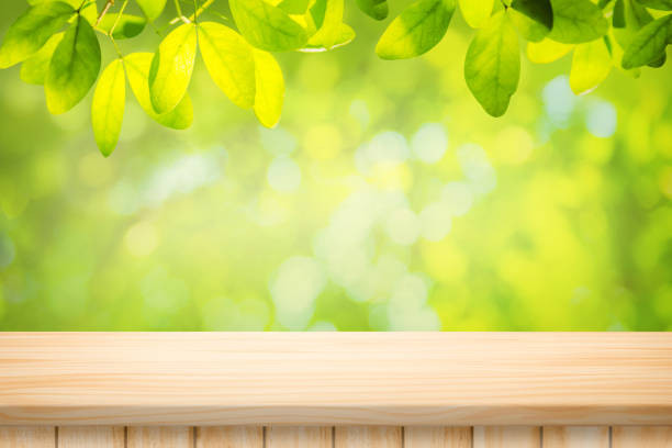 istock Wood table floor and beautiful natural green leaf abstract blurred bokeh light background 1370095624