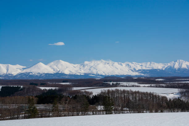 istock Upland field where snow remains and snowy mountains 1370097948