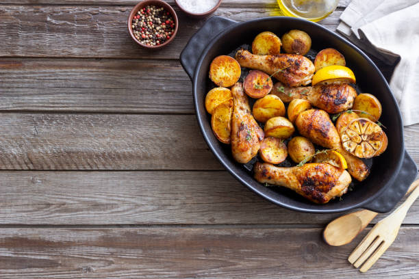 istock Baked chicken legs with potatoes and lemon. Recipe. 1370098322
