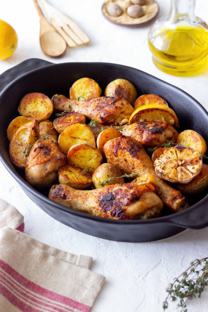 istock Baked chicken legs with potatoes and lemon. Recipe. 1370098621