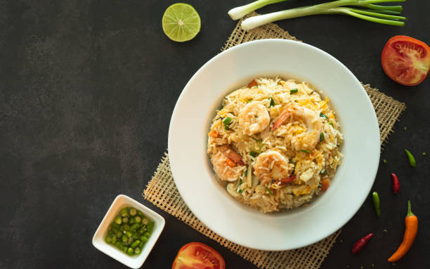 istock Asian fried rice with eggs, shrimp, vegetables and spice, closed up top view with space for text. 1370099611