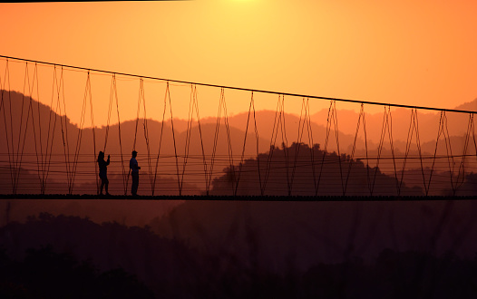 Couple tourism in the nature,they are explorer and adventure on suspension bridge ,ecotourism concept.