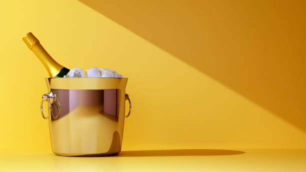 bucket of champagne and ice on yellow background stock photo