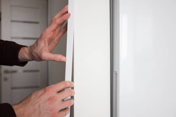 istock Mans hands installing protective decorative corner on the wall in apartment. 1370100256