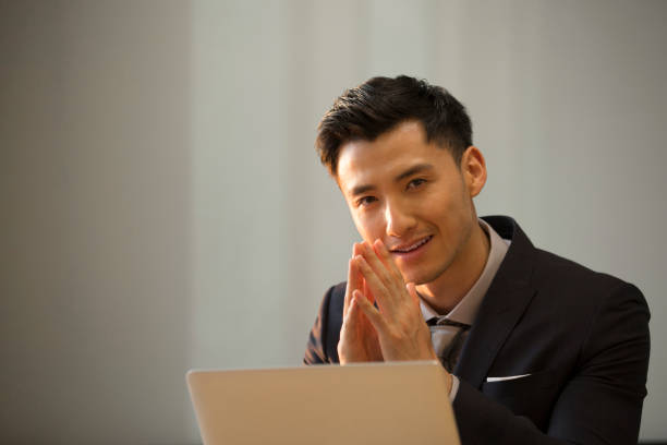Chinese businessman works using a laptop in an office stock photo