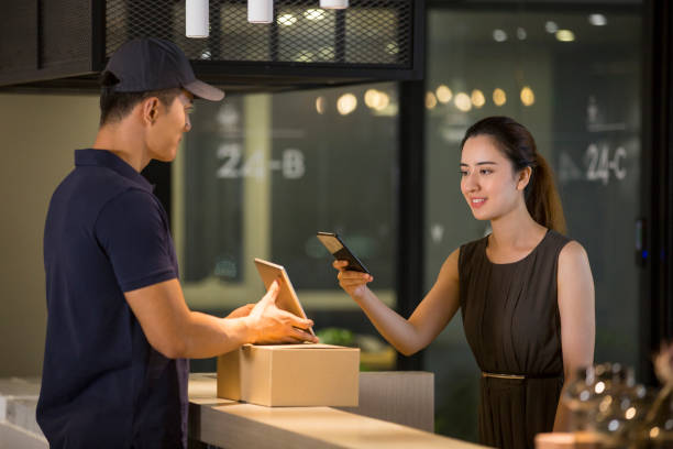 istock Chinese receptionist pays delivery man with her mobile phone 1370101480