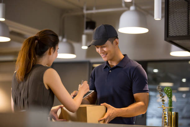 istock Chinese receptionist signing for delivery in office 1370101504