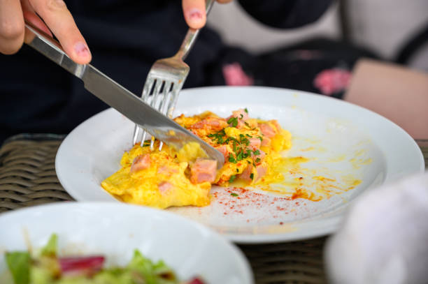 messer und gabel zum zerschneiden eines omeletts - eierkuchen speise stock-fotos und bilder