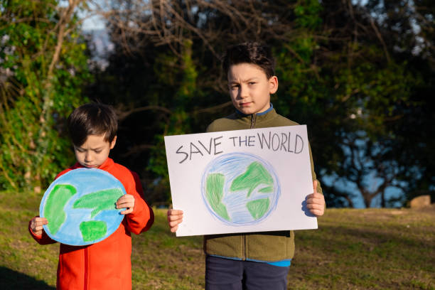 istock Child holding sign with world drawing in meadow 1370106285