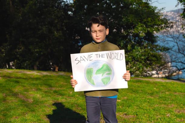 istock Child holding sign with world drawing in meadow 1370106298